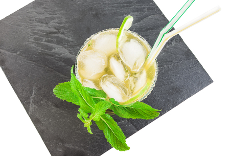 Black serving slate platter with glass of mojito cocktail isolated over white background. Top view.の写真素材