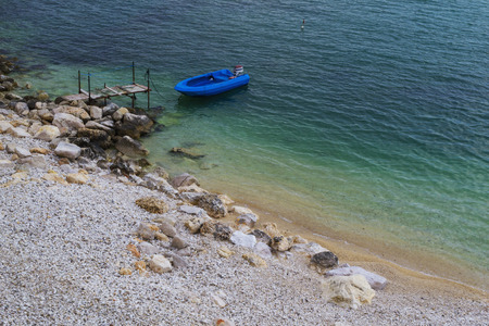 Small boat berthed. Blue and green sea around.の写真素材