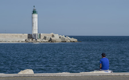 The lighthouse and the fishermanの写真素材
