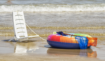 A white chair and a colorful life belt.の写真素材
