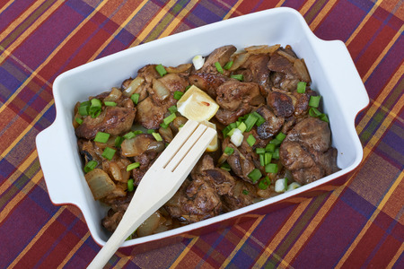 Fried chicken liver in a ceramic plate isolated on a checkered tablecloth, home cookingの写真素材