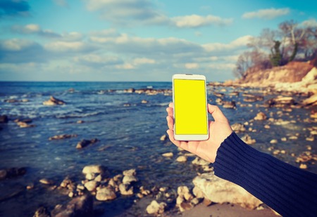 White smart phone on the background Black Sea in female hands, effectの写真素材