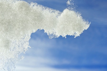 Spring background with icicles. An ice edge against the blue sky.