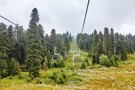 Emtpy chairlift in ski resort. Mountains and hills with in Summer with green trees and grassの写真素材