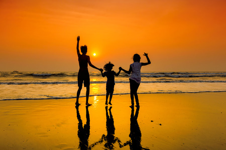 Group of happy young people dancing at the beach on a beautiful summer sunset.の写真素材