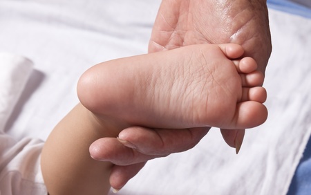Baby foot in grandmother handの写真素材