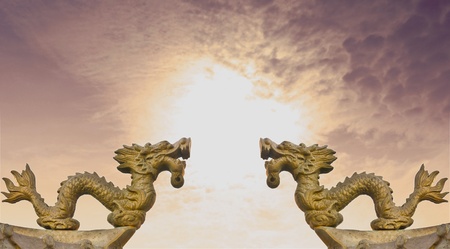 Two brass dragon statue under blue skyの写真素材