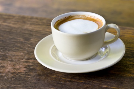 Coffee cappuccino cup on wood table in morning