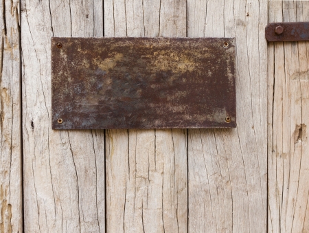 Old and rust metal sign on wood plank backgroundの写真素材