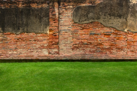 Old brick wall background with green grassの写真素材