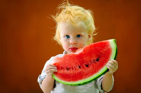 Cute infant baby with a delicious melonの写真素材