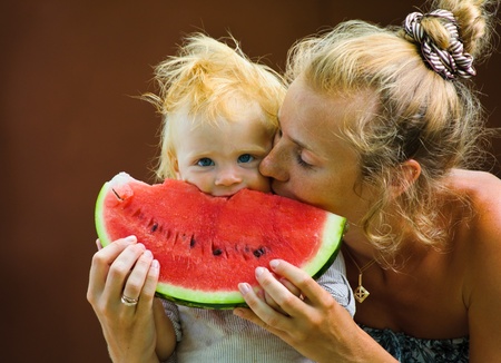 Cute infant baby with a delicious melonの写真素材