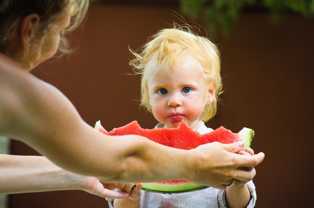 Cute infant baby with a delicious melonの写真素材