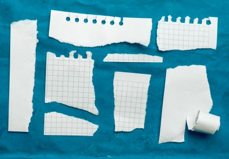 Collection of white ripped pieces of paper on blue backgroundの写真素材