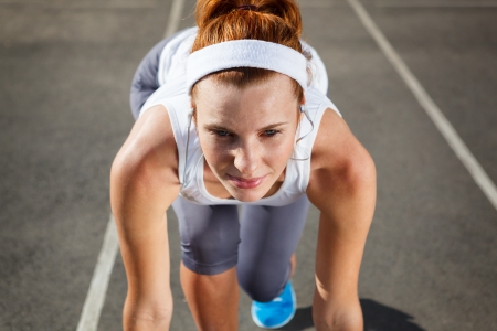 Woman getting ready to start on Stadium - summer outdoors training の写真素材