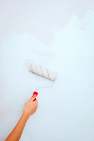 Hand with roller brush painting wall の写真素材
