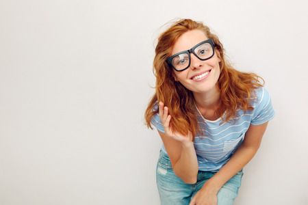 Portrait of happy Young woman with black glasses standing against wall の写真素材