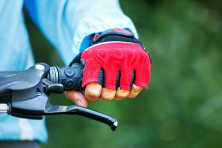 Closeup of hands in red protective gloves holding handlebar.の写真素材