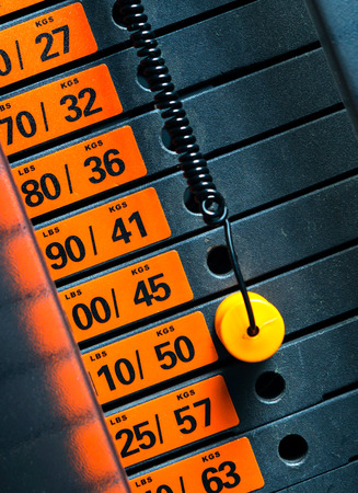 Closeup of weight stack with orange pin.