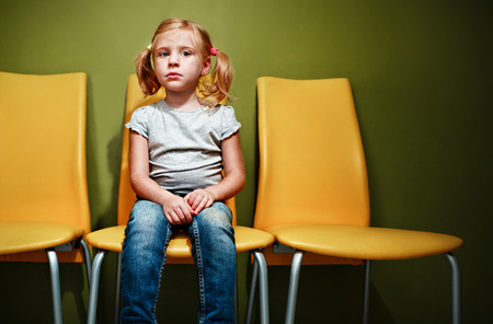 Little redhead girl waiting in reception room.の写真素材