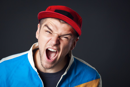 Studio portrait of screaming young guy in studio.