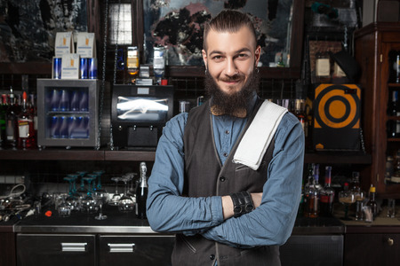 Happy barman at work with crossed hands.の写真素材