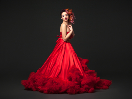 Beautiful girl in red dress with curly hair.の写真素材