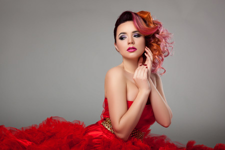 Beautiful girl sitting in red dress.の写真素材