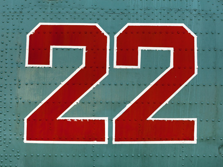 Old red 22 numbers on aircraft fuselage close up.