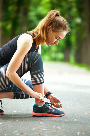 Shot of a beautiful young woman tying her laces before a run.の写真素材