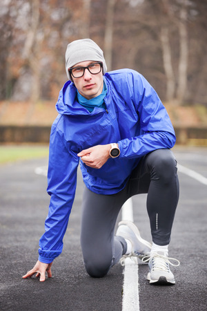 Shot of a young handsome professional runner looking at camera outdoors.の写真素材