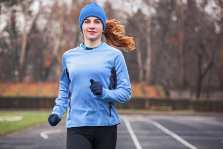 Cropped shot of a happy young woman running outdoors.の写真素材