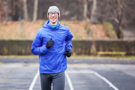 Cropped shot of a happy young man running outdoors.の写真素材