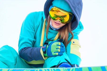 Close up of young snowboarder holding her injured leg.の写真素材