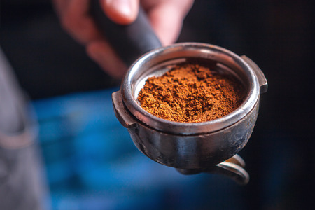 Close up of barista holding portafilter for espresso coffee machine.の写真素材