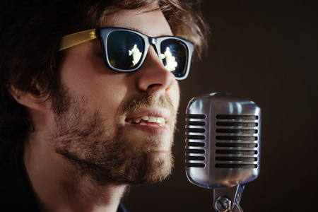 Handsome rock singer with retro microphone.の写真素材