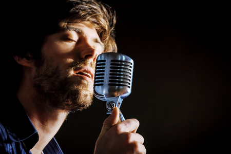 Handsome rock singer with retro microphone.の写真素材
