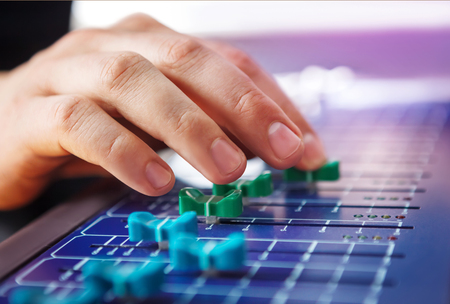 Professional audio engineer adjusting mixing concole.の写真素材
