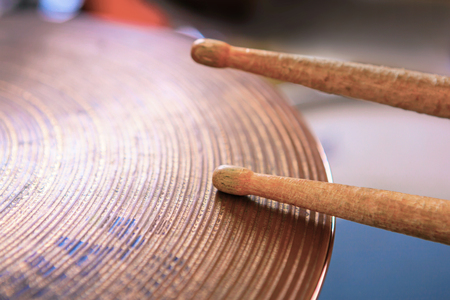Close up of a pair of drumsticks lying on cymbal.の写真素材