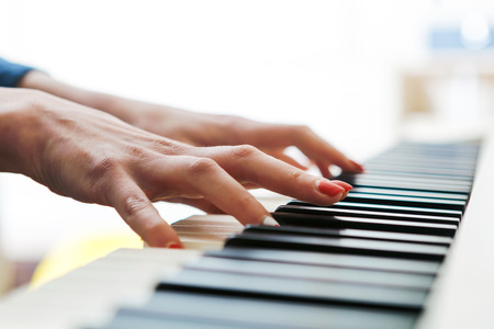Close up of pianists hands playing piano. Shallow deep of field.の写真素材