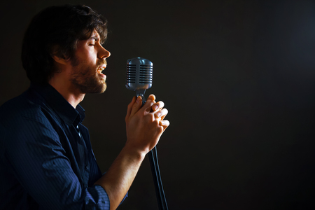 Handsome rock singer with retro microphone.の写真素材