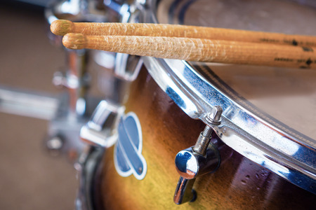 Close up of a pair of drumsticks lying on tom-tom drum.の写真素材