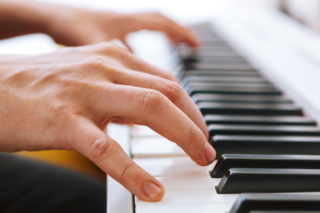 Close up of pianists hands playing piano. Shallow deep of field.の写真素材
