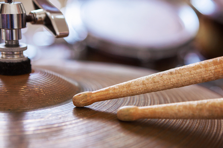 Close up of a pair of drumsticks lying on cymbal.の写真素材