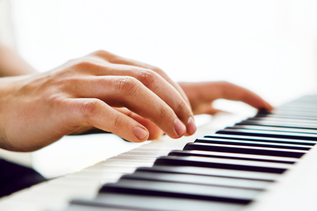 Close up of pianists hands playing piano. Shallow deep of field.の写真素材