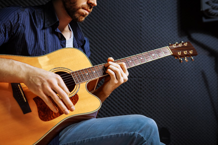 Handsome rock guitarist practicing in sound studio.の写真素材