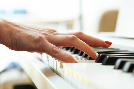 Close up of pianists hands playing piano. Shallow deep of field.の写真素材