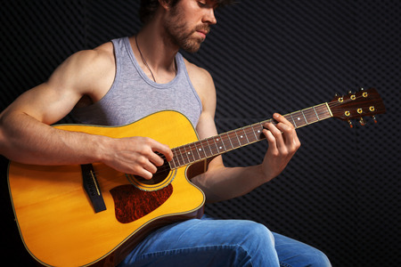 Handsome rock guitarist practicing in sound studio.の写真素材