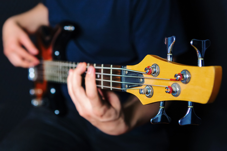 Closeup of rock guitarist practicing with bass guitar.の写真素材