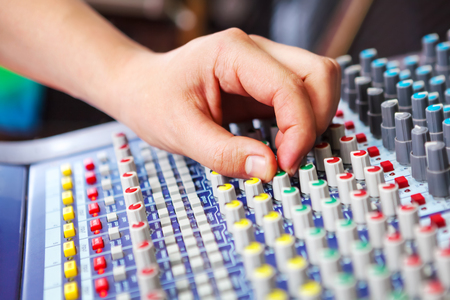Professional audio engineer adjusting mixing concole.